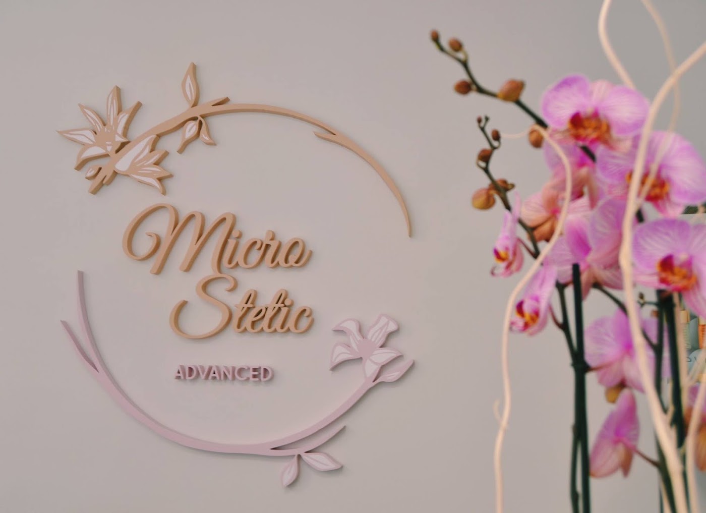 Logotipo de Micro Stetic Advanced junto a una orquídea